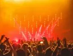 A crowd of people in front of a stage at a concert.