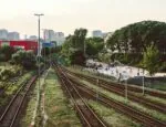 Train tracks converging near a city.