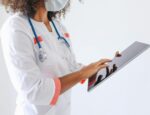 A health care worker holding an electronic tablet.