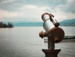 A telescope looking out at a lake.