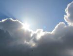 The sun peeking behind clouds.