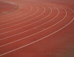 The curve of a red-brown running track.